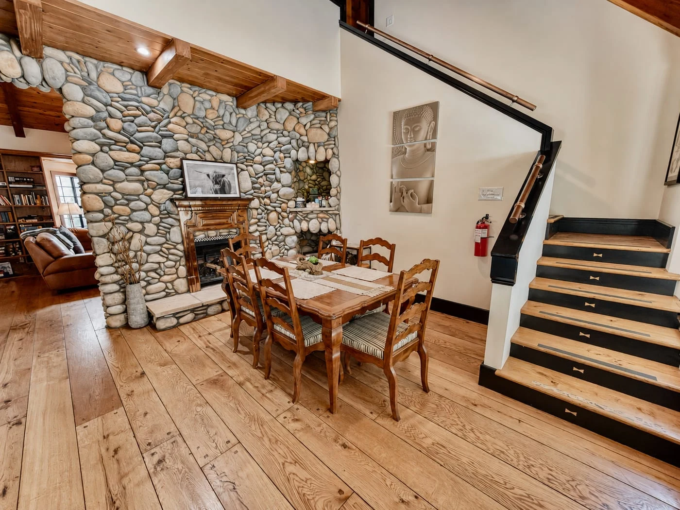 The dining area beside the river-stone fireplace