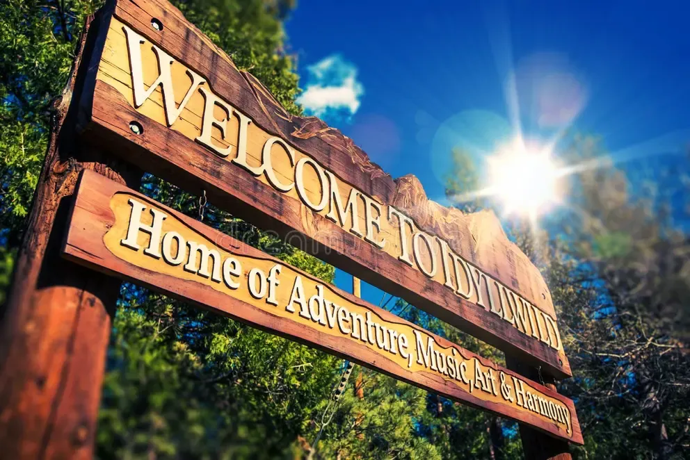 Wooden welcome sign for Idyllwild beneath a blue sky.
