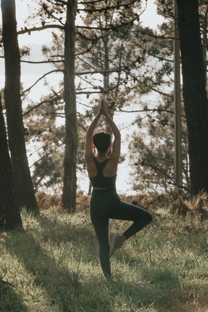 Young woman doing yoga in pine forest