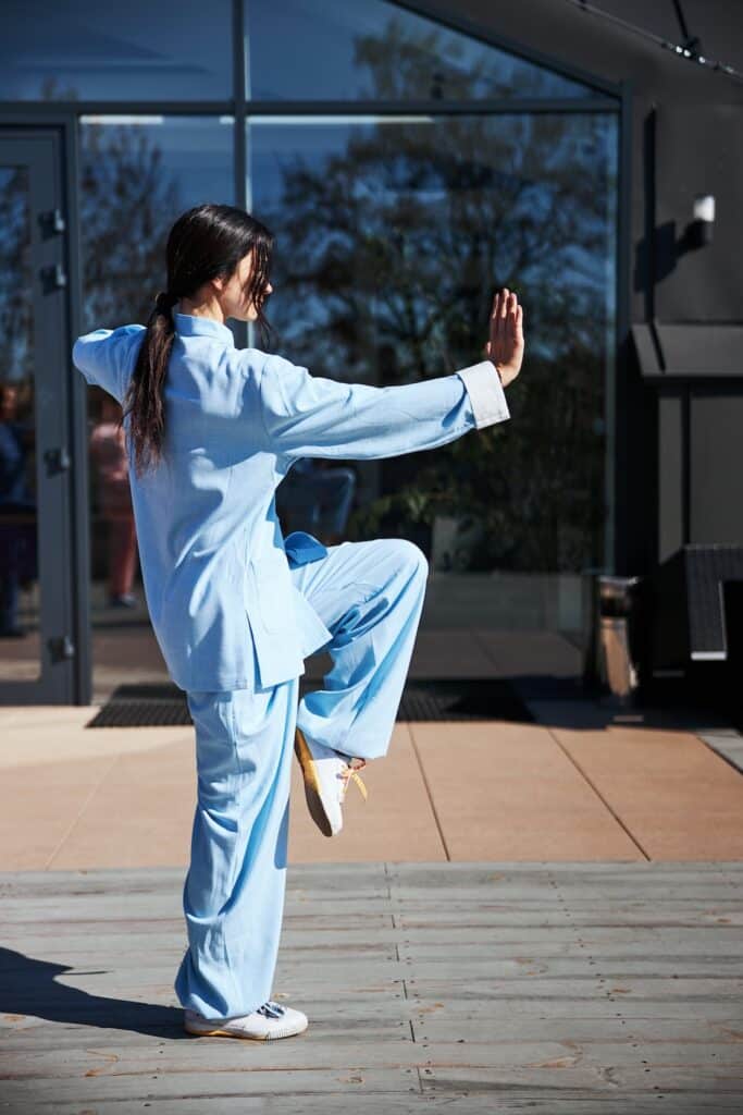 Woman practicing tai chi outside.