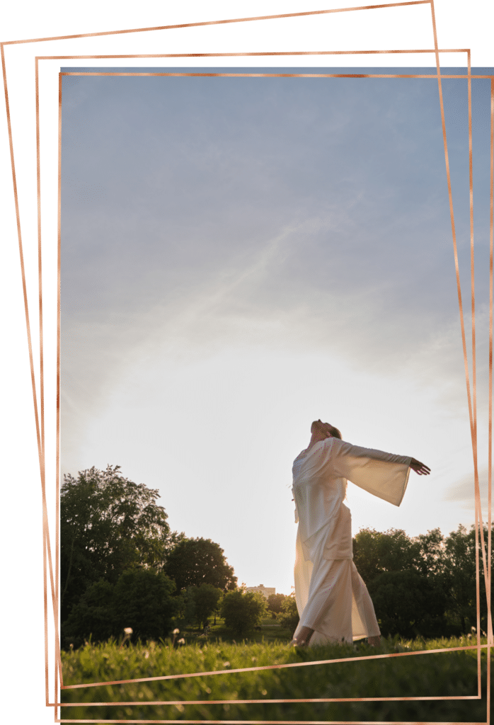 Woman practicing tai chi outside at sunset.