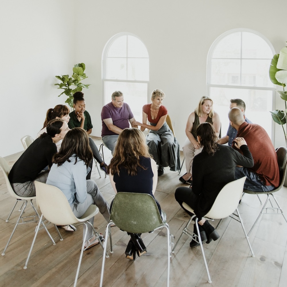 Group of clients sits in a circle during therapy