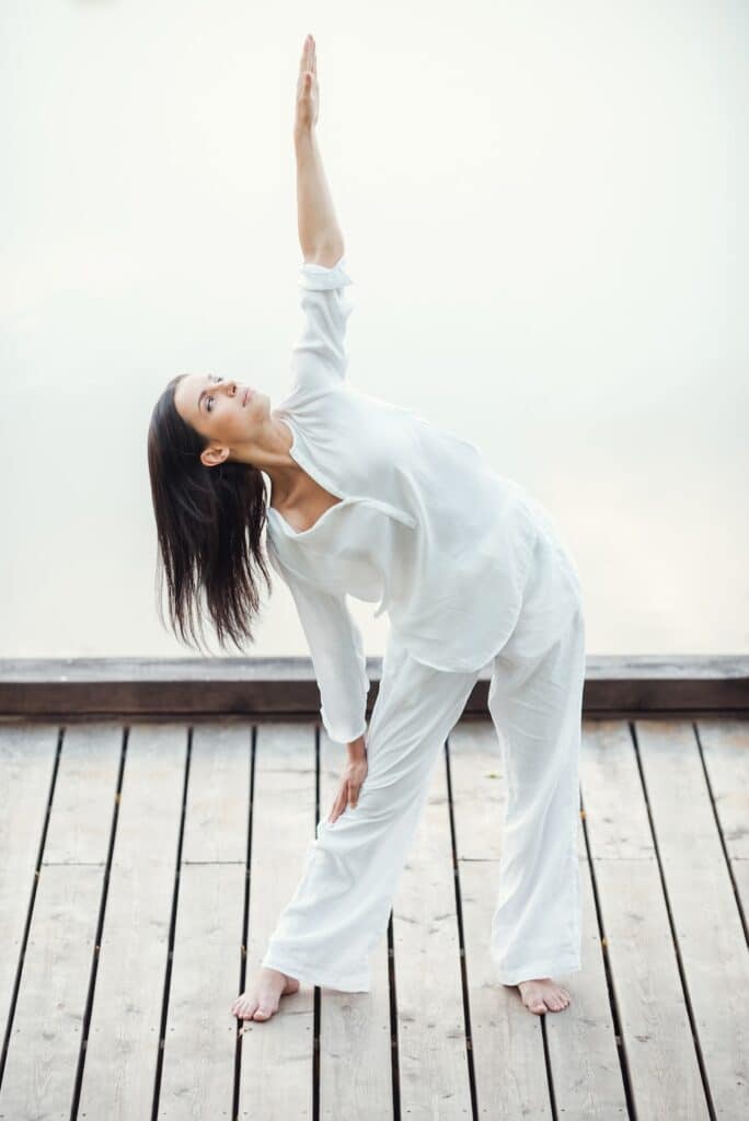 Woman stretching arm toward sun