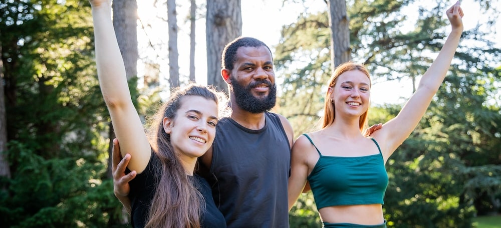 Three smiling people in the forest