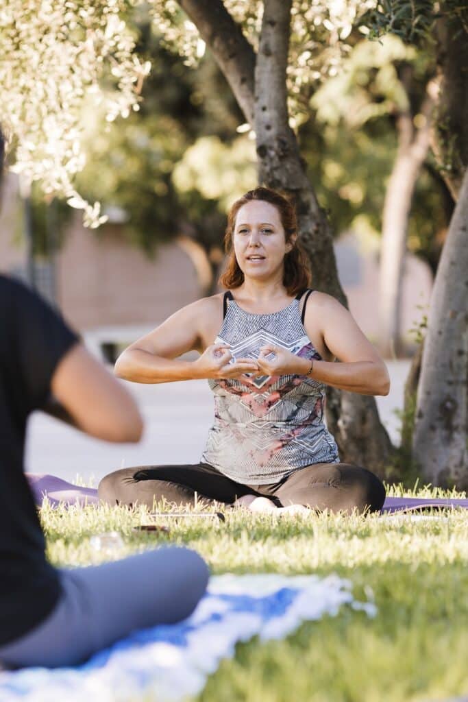 Instructor in yoga pose giving classes outdoors