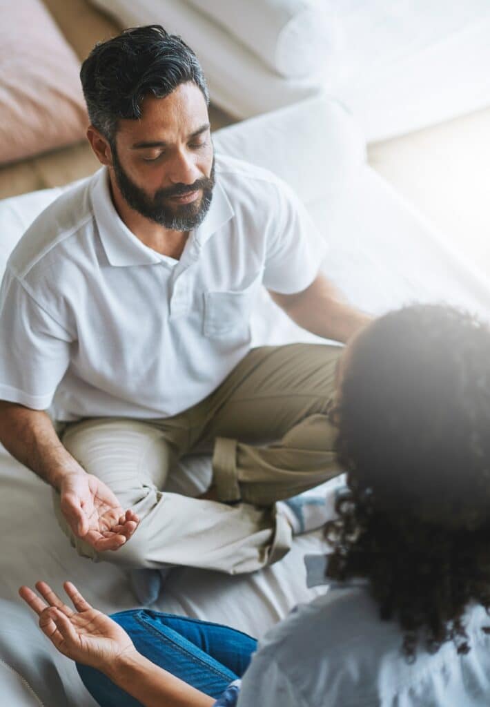 Young man and therapist sitting in mindful meditation