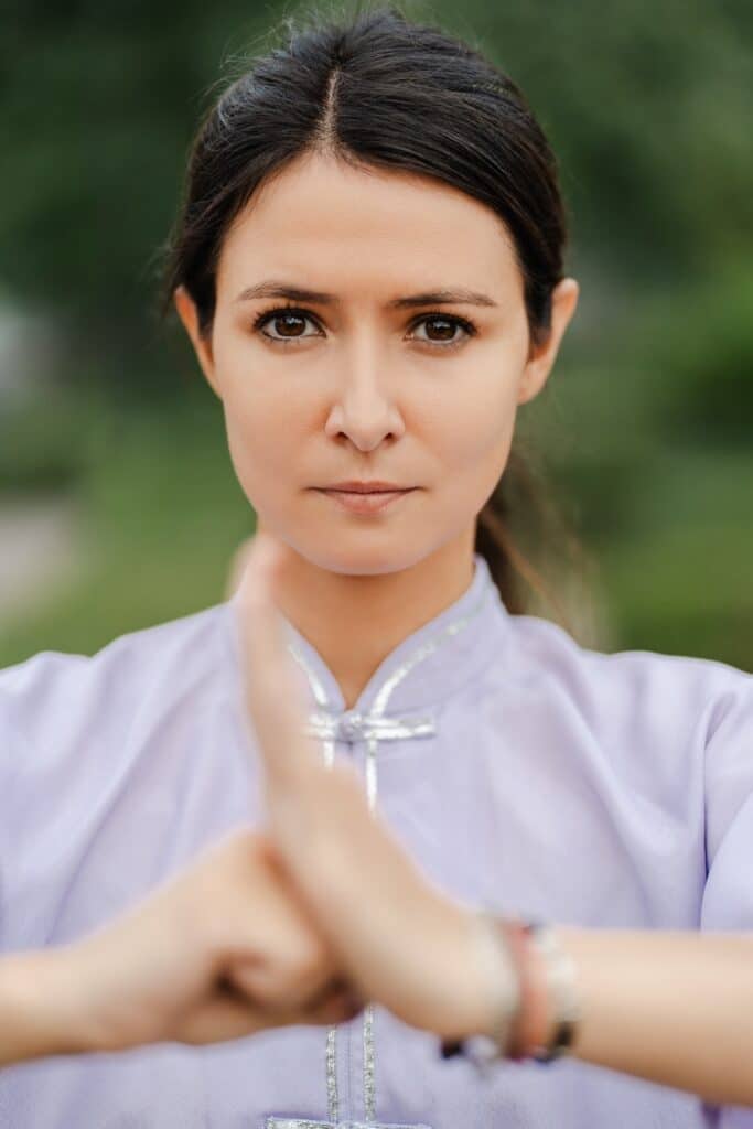 Focused woman training balance and looking at camera while exercising