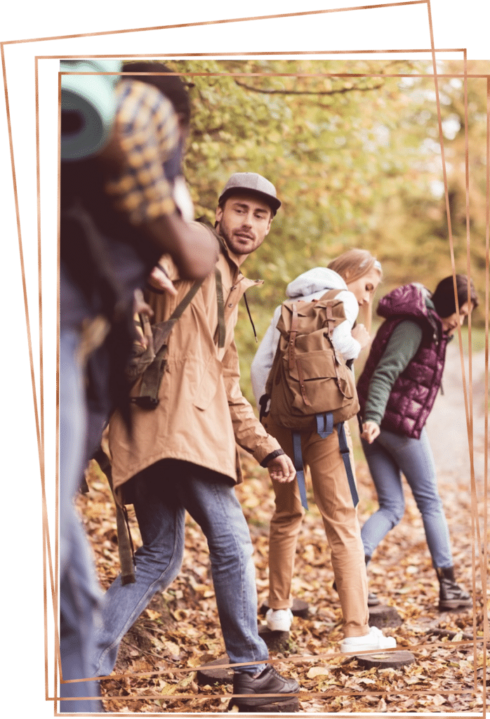 Group of friends hiking together in the woods during the fall.