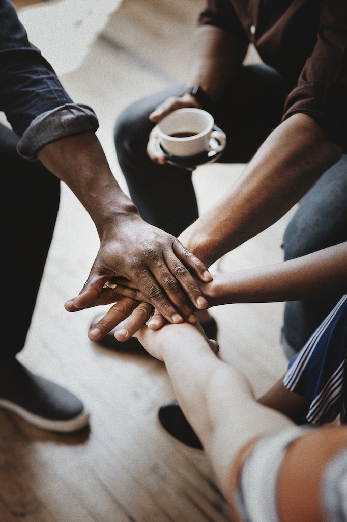 Diverse people joining hands in the middle