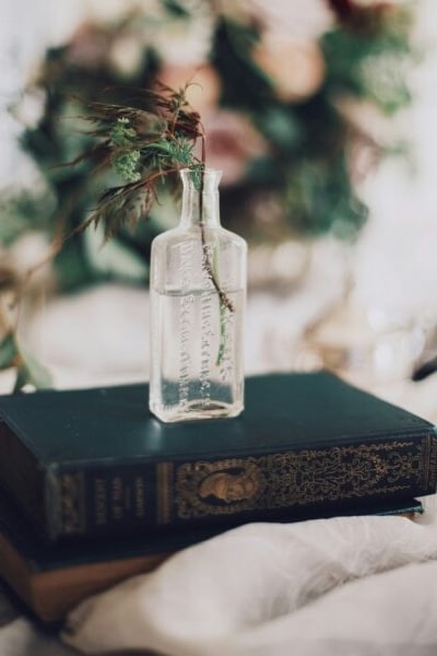 Herb sitting in a glass on top of vintage book.