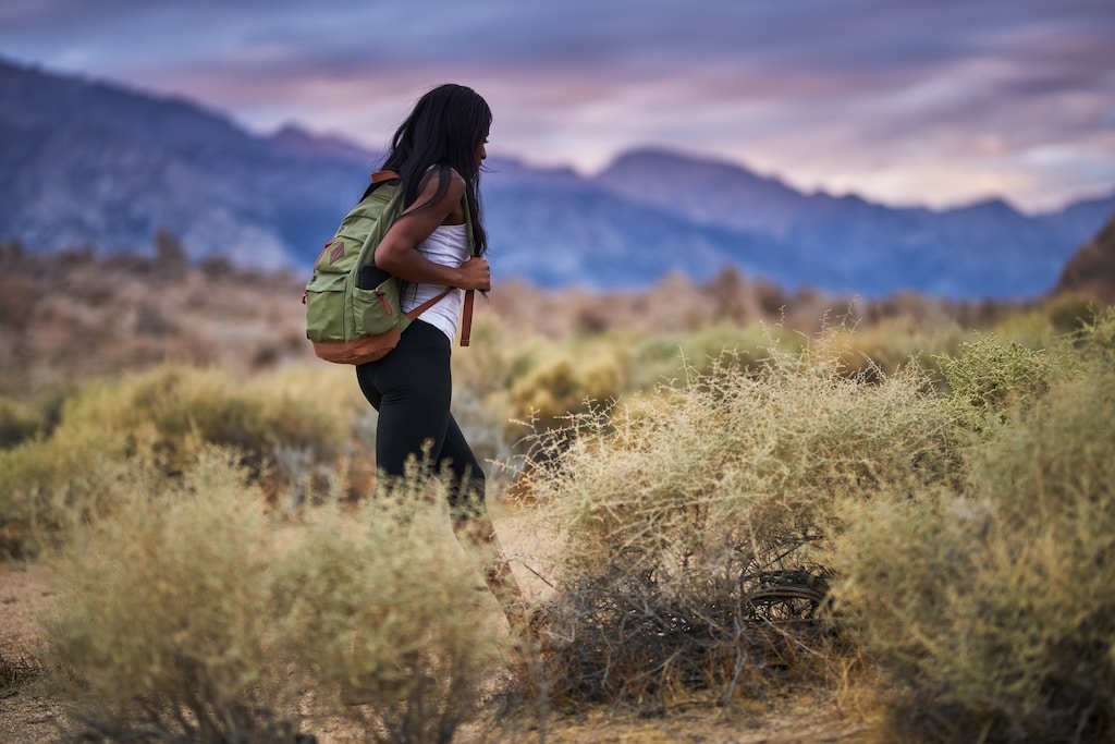 Young woman hiking through hills in California.