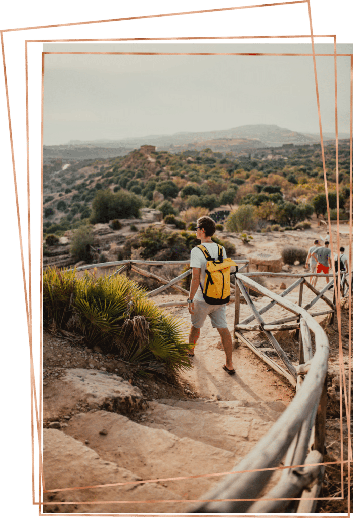 Young man from behind, hiking in California landscape.