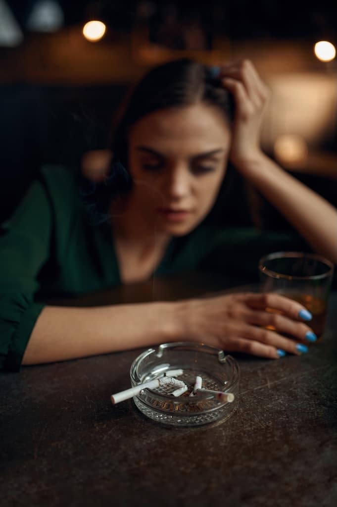 Drunk tired woman sitting at the counter in bar.